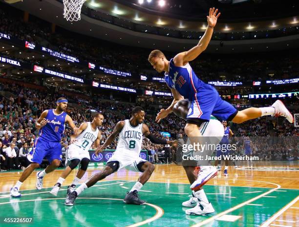 Blake Griffin of the Los Angeles Clippers jumps on the back of Brandon Bass of the Boston Celtics in the second half during the game at TD Garden on...