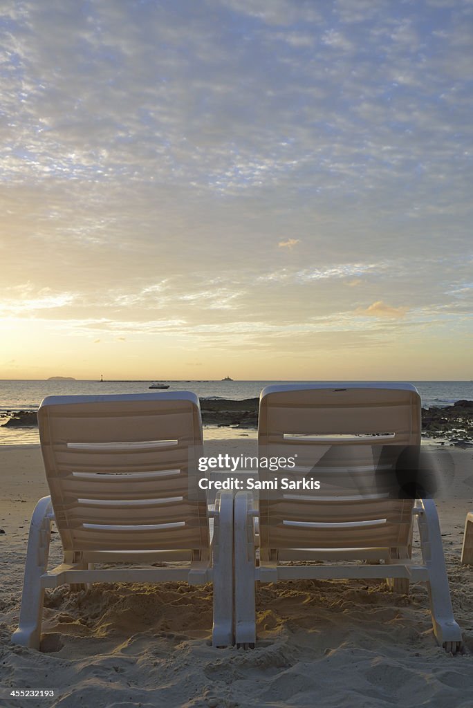 Sunloungers on a tropical beach at sunrise