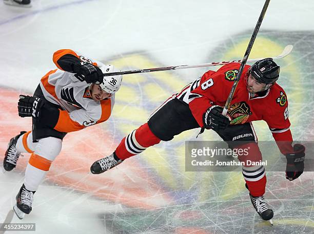 Zac Rinaldo of the Philadelphia Flyers hits Nick Leddy of the Chicago Blackhawks with his stick at the United Center on December 11, 2013 in Chicago,...