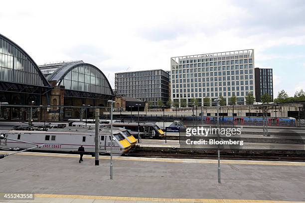 High speed East Coast mainline passenger trains stand at platforms at the King's Cross railway station as the Pancras Square development stands on...