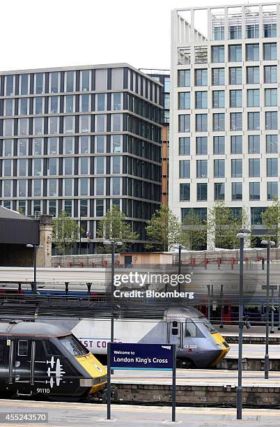 High speed East Coast mainline passenger trains stand at platforms at the King's Cross railway station as the Pancras Square development stands on...