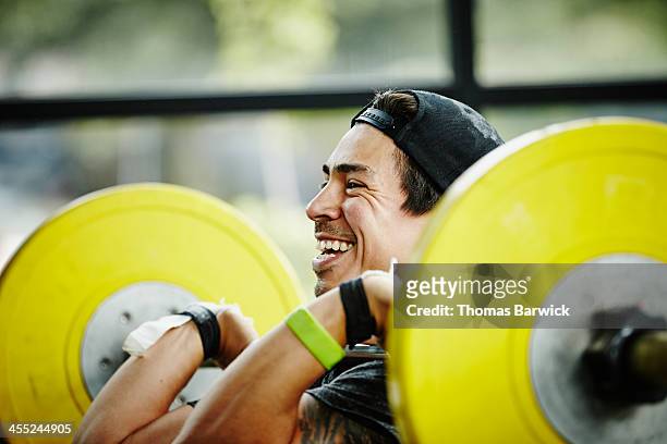 smiling man preparing to press barbell over head - barra de peso - fotografias e filmes do acervo