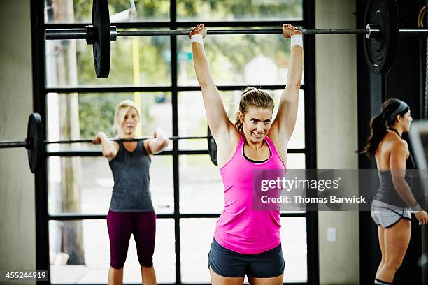 women doing snatch with barbell in gym gym - snatch stock-fotos und bilder