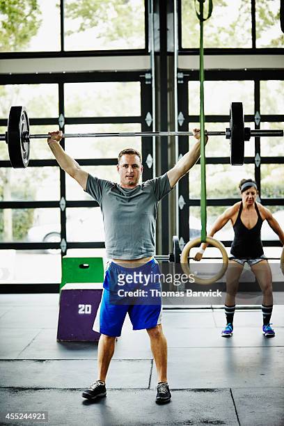 man doing snatch with barbell in gym gym - snatch weightlifting stockfoto's en -beelden