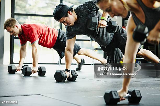 group of friends doing pushups with dumbbells - treino de força imagens e fotografias de stock