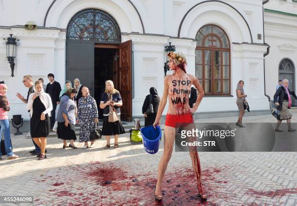 Femen activist with the inscription "Stop Putin's war" on her body protests against the politics of Russia in Kiev Pechersk Lavra on September 11,...