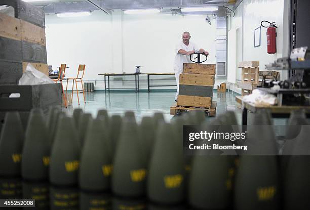 An employee pushes a trolley loaded with wooden boxes towards a store of 122mm M60 smoke shell casings at the state-run Sloboda AD ammunitions plant...