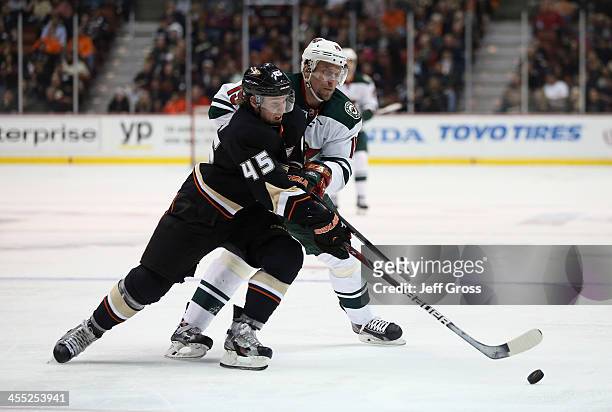 Sami Vatanen of the Anaheim Ducks and Dany Heatley of the Minnesota Wild fight for the puck in the second period at Honda Center on December 11, 2013...