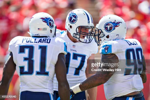 Karl Klug is congratulated by teammates Bernard Pollard and Jurrell Casey of the Tennessee Titans after sacking the quarterback during a game against...
