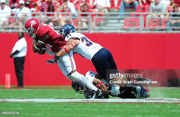 ArDarius Stewart of the Alabama Crimson Tide is tackled by Sharrod Neasman and Grant Helm of the Florida Atlantc Owls at Bryant-Denny Stadium on...