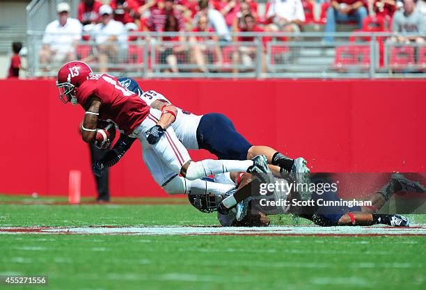 ArDarius Stewart of the Alabama Crimson Tide is tackled by Sharrod Neasman and Grant Helm of the Florida Atlantc Owls at Bryant-Denny Stadium on...