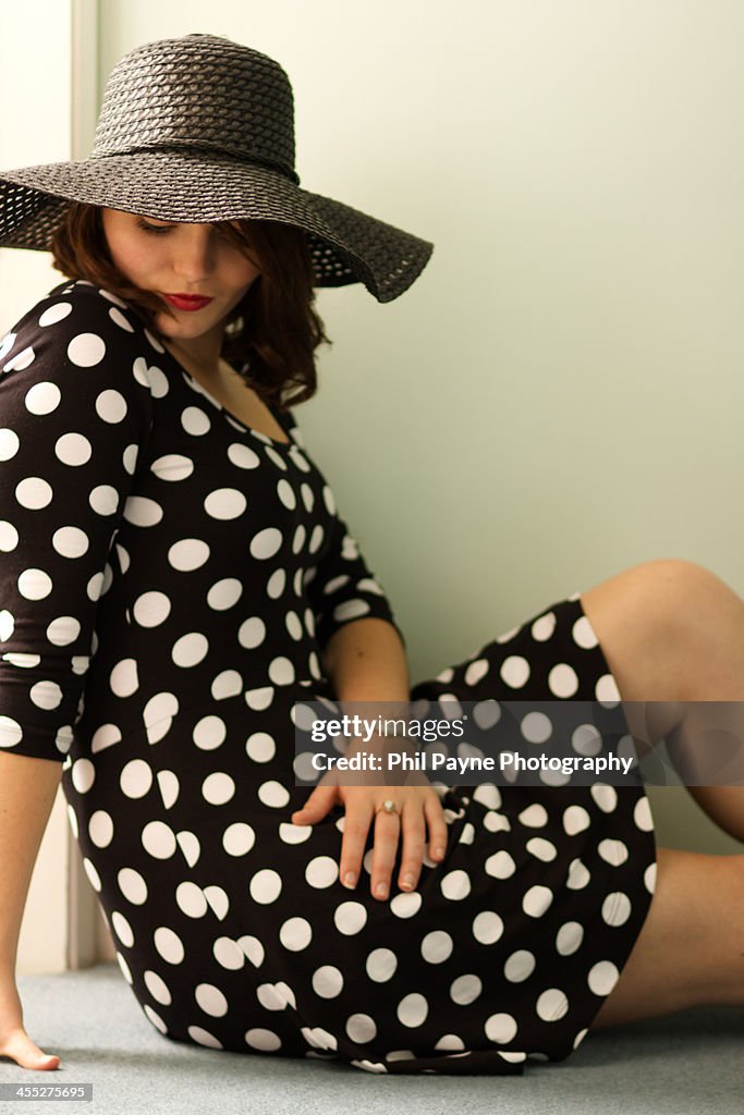 Woman wearing a hat sits in doorway