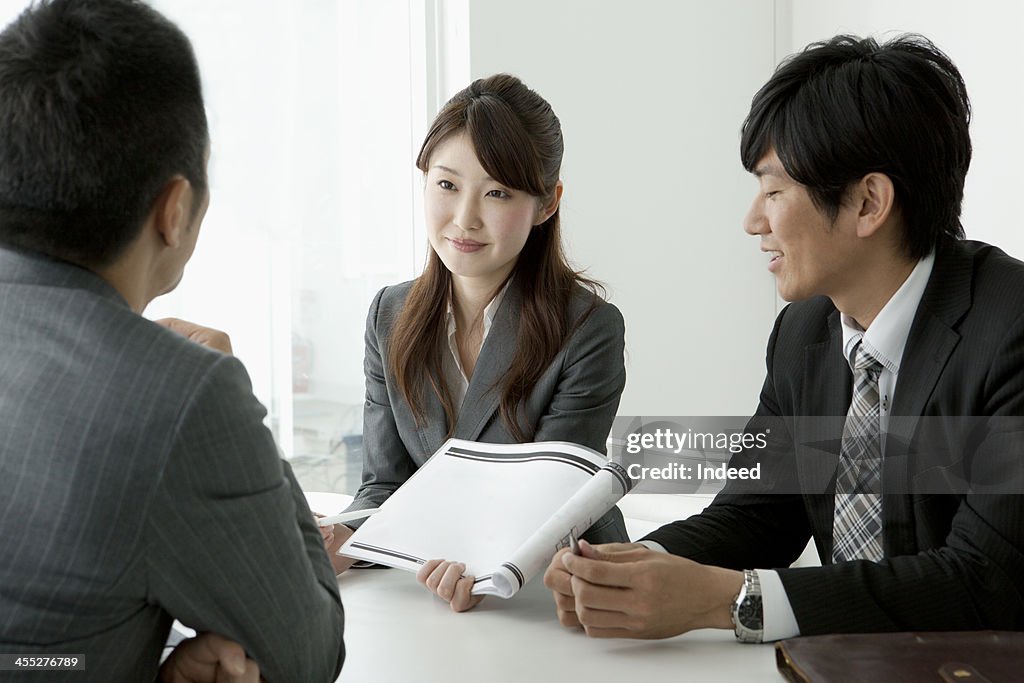 BUSINESS SCENE Three persons in a meeting