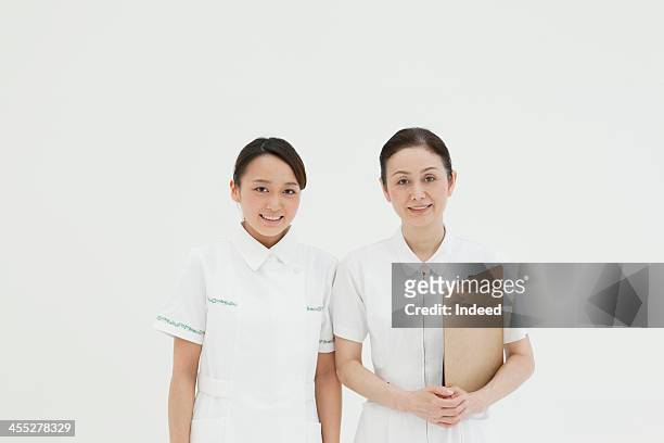 charge nurse and young nurse - nurse and portrait and white background and smiling and female and looking at camera stock pictures, royalty-free photos & images