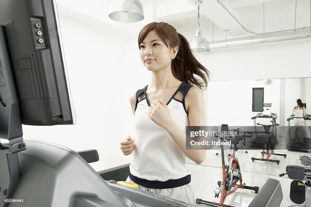 Woman runs by treadmill