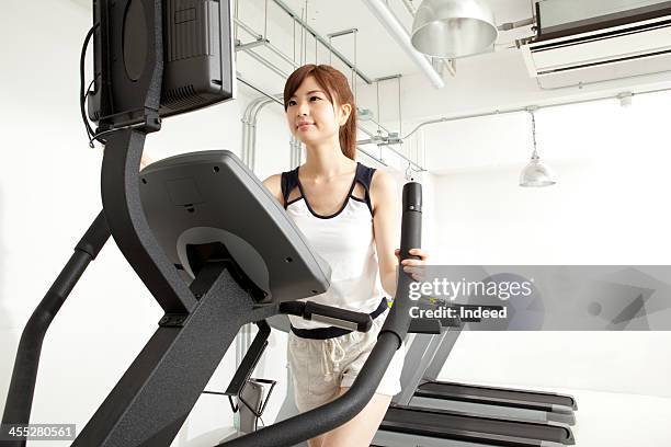 woman takes exercise in the gym - フィットネスマシン ストックフォトと画像