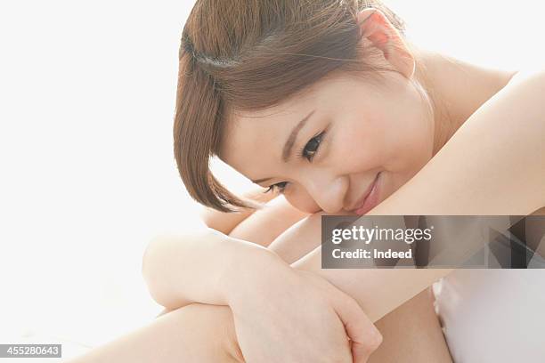 woman smiles by sitting - hugging knees stock pictures, royalty-free photos & images