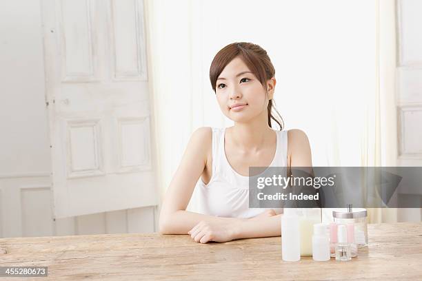 woman sits with cosmetics - tank top ストックフォトと画像