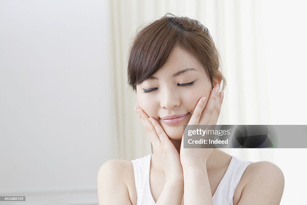 Woman holds cheeks by hand