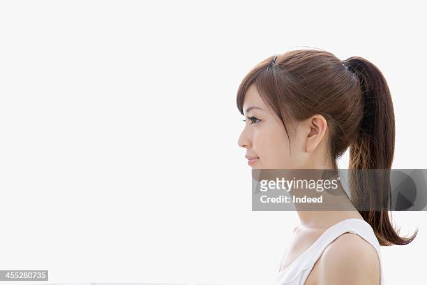sideways-facing of woman dressed in tank top - ponytail hairstyle stock pictures, royalty-free photos & images