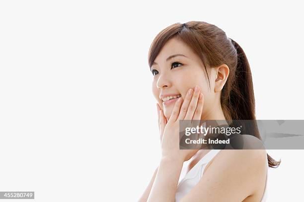 woman holds cheeks by hand - mejilla fotografías e imágenes de stock