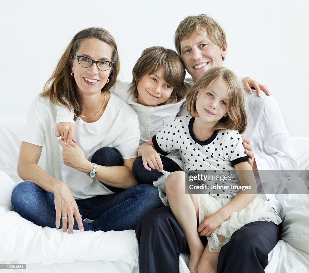 Happy family sitting on sofa, studio shot