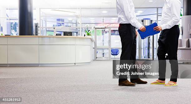two businessmen meeting, low section - ciabatta infradito foto e immagini stock