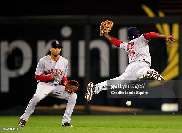 Jemile Weeks of the Boston Red Sox leaps but misses a blooper hit by Alcides Escobar of the Kansas City Royals in shallow left field as Yoenis...