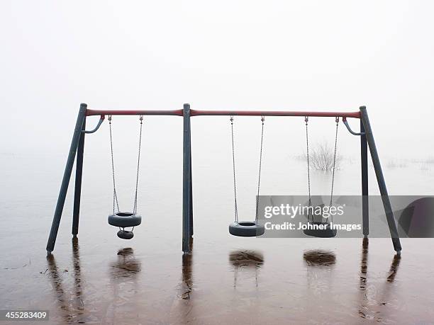 abandoned playground - schaukel regen stock-fotos und bilder