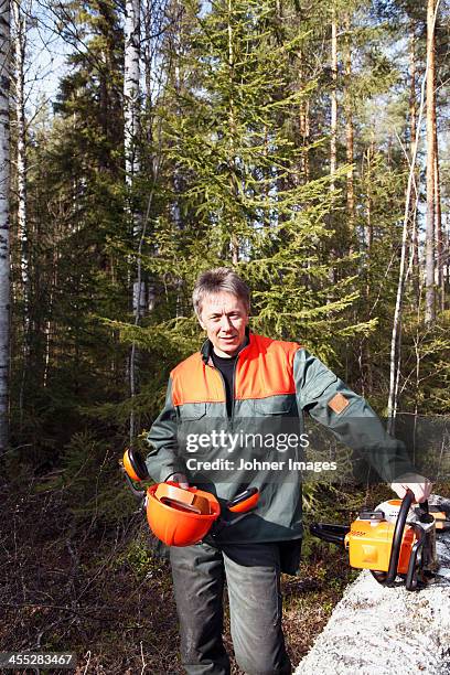 Portrait Of Man With Chainsaw In Forest, Stockfoto