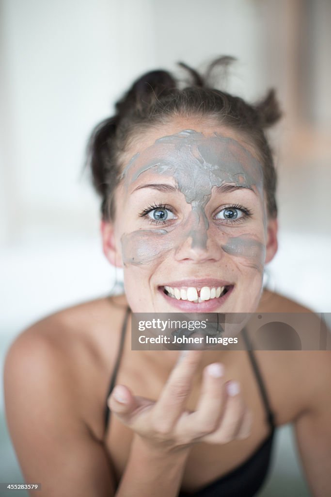 Young woman using face mask