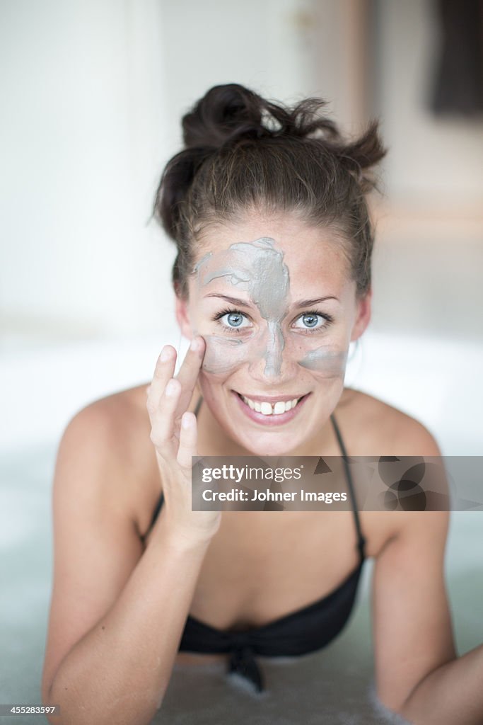 Young woman using face mask