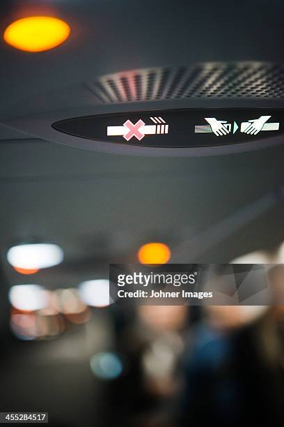 fasten seatbelt sign and non-smoking sign in airplane - wohngebäude innenansicht stock-fotos und bilder