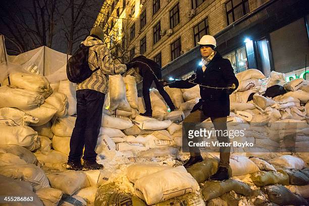 Protesters installing a barbed wire on a new reinforced barricade on Maidan Square on December 11, 2013 in Kiev, Ukraine. Thousands have been...