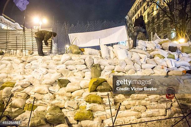 Protesters installing metal sheet barriers and barbed wire on a new reinforced barricade on Maidan Square on December 11, 2013 in Kiev, Ukraine....