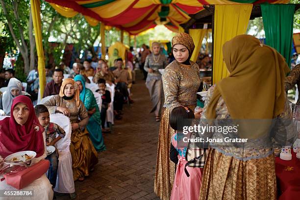 Beautifully dressed women at a lavish wedding in Banda Aceh. After the tsunami flooded the financial aid set, much was lost to corruption and Aceh...