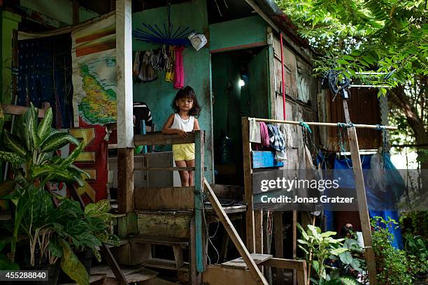 Young girl standing outside of her family's home in a makeshift IDP camp that was built after the 2004 tsunami - intentionally built to be a...