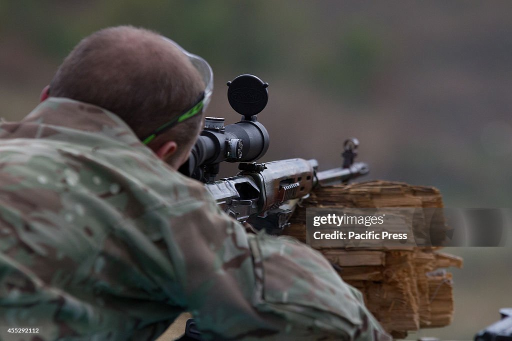 A soldier of Aidar battalion aims a rifle during military...