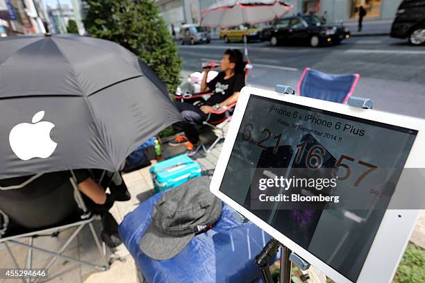 An Apple Inc. IPad counts down to the sales launch of the company's iPhone 6 and iPhone 6 Plus as Tetsuya Tamura, the first customer in line who has...