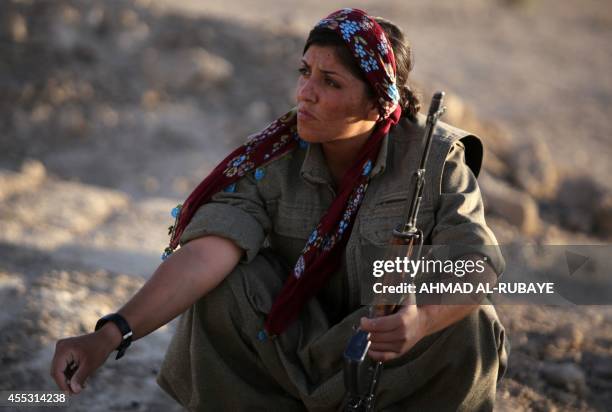 Picture taken on August 21, 2014 shows a woman Kurdistan Workers Party fighter guarding a post on the front line in the Makhmur area, near Mosul,...