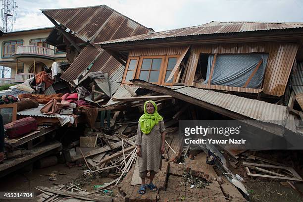 Kashmiri Muslim woman wails in front her collapsed residential house due to floods in a flooded area on September 12, 2014 in Srinagar, the summer...