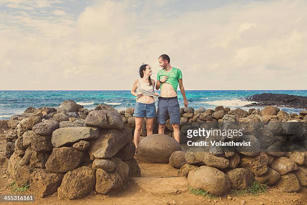 couple showing navel in the 'world navel' rock - easter_island stock pictures, royalty-free photos & images