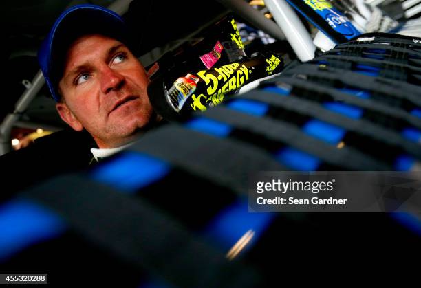 Clint Bowyer, driver of the PEAK Radiator Guarantee Toyota, sits in his car during practice for the NASCAR Sprint Cup Series MyAFibStory.com 400 at...