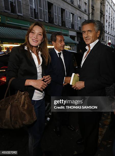 French former president Nicolas Sarkozy and his wife French singer Carla Bruni are greeted by French writer and philosopher Bernard Henri-Levy on...