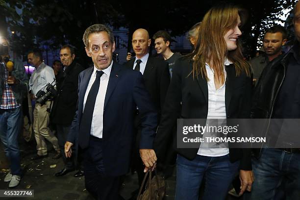 French former president Nicolas Sarkozy and his wife French singer Carla Bruni arrive at the Theatre de l'Atelier in Paris on September 12 to attend...