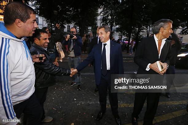 French former president Nicolas Sarkozy shakes hands with people as he arrives to attend the premiere of the play "Hotel Europe" by French writer...