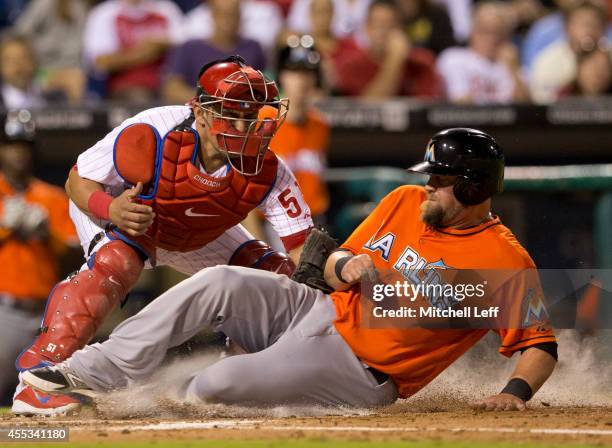 Third baseman Casey McGehee of the Miami Marlins is tagged out at home by catcher Carlos Ruiz of the Philadelphia Phillies in the top of the fourth...