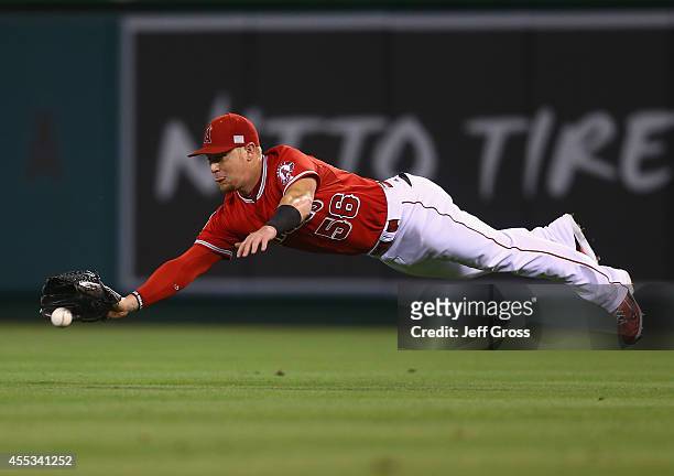 Right fielder Kole Calhoun of the Los Angeles Angels of Anaheim dives for a ball hit by Jose Altuve of the Houston Astros but isn't able to make the...