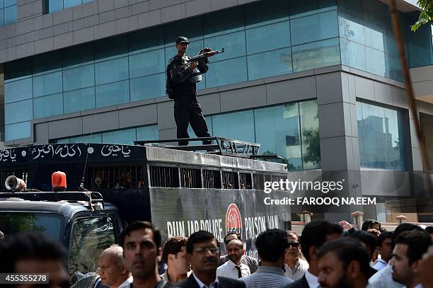 Activists of Pakistan Tehreek-e-Insaf gather around a police prison van carrying arrested workers to prevent them from leaving the court area in...