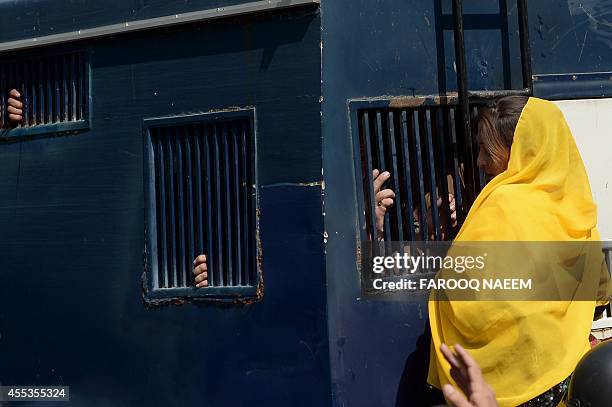 Activists of Pakistan Tehreek-e-Insaf gather around a police prison van carrying arrested workers to prevent them from leaving the court area in...